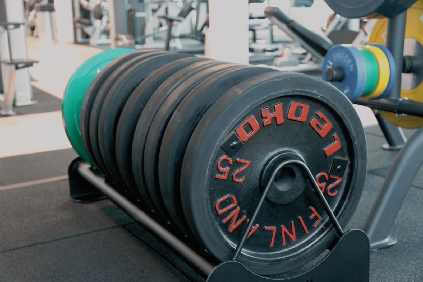 Close-up of stacked weight plates on a rack in the studio
