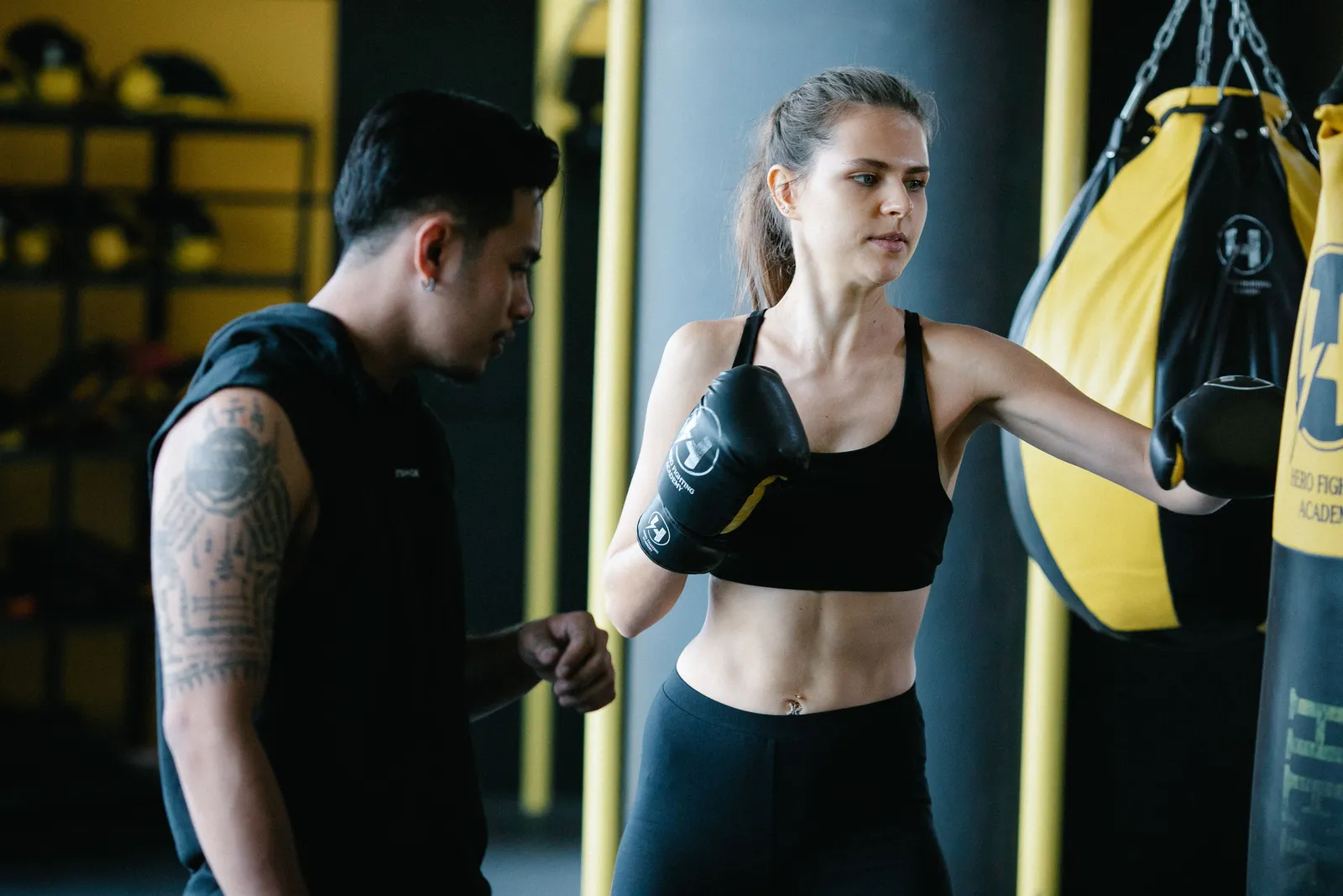A coach holding pads for a boxer's punch combination