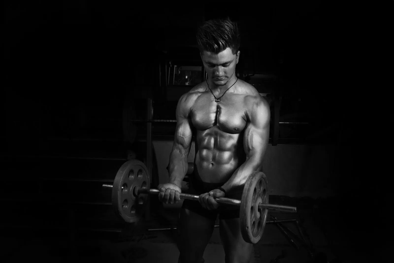 Athlete lifting a barbell in a dark studio